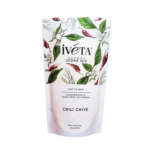 Front: iveta Chili Chive Scone Mix. A bag of dry ingredients for making savory chili chive scones. Dried chives and chili flakes are visible in the mix. "Easy to Bake" and "Handcrafted in Santa Cruz, California" are also on the bag.
